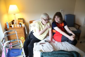 Project SEARCH intern Haley McCormick-Thompson lends an attentive ear to a resident at United Hebrew New Rochelle (photo credit POSITIVE EXPOSURE)