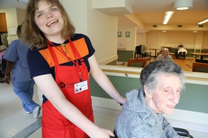 Project SEARCH intern Haley McCormick-Thompson having a good time while transporting a resident at United Hebrew New Rochelle (photo credit POSITIVE EXPOSURE)