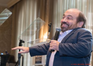 Danny Woodburn smiling and pointing