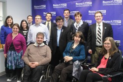 Fellows posing with Maria Towne in front of a RespectAbility banner