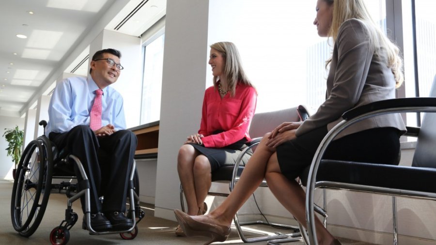 Won Shin, senior manager in transaction advisory services at EY, speaks with coworkers Alejandra Preciat and Frances Smith (photo credit POSITIVE EXPOSURE)