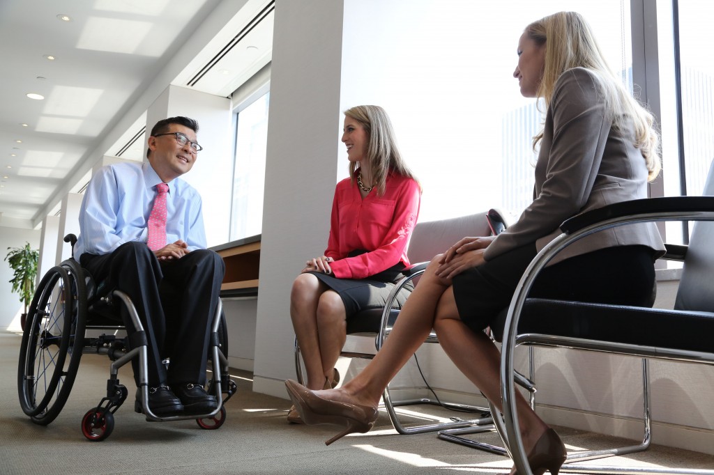 Won Shin, senior manager in transaction advisory services at EY, speaks with coworkers Alejandra Preciat and Frances Smith (photo credit POSITIVE EXPOSURE)