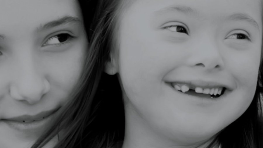 Image of two girls smiling and looking off into the distance.