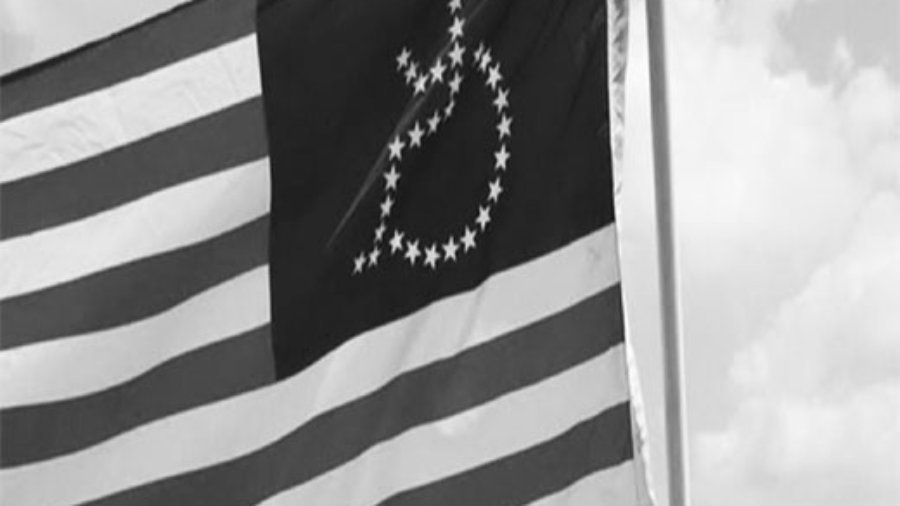 A black and white photo of an American flag with the stars in shape of a wheelchair