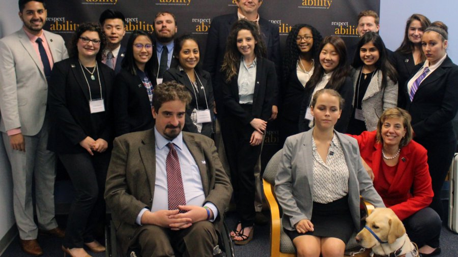 Dan Hazelwood and RespectAbility Fellows standing and seated in a posed photograph, smiling for the camera