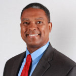 headshot of Gerard Robinson, wearing a gray suit, blue shirt and red tie