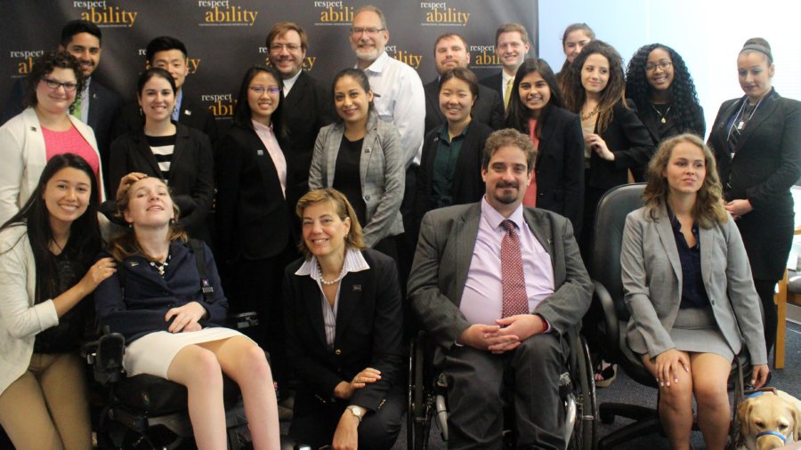 Jonathan Kessler and RespectAbility Fellows standing and seated in a posed photograph, smiling for the camera
