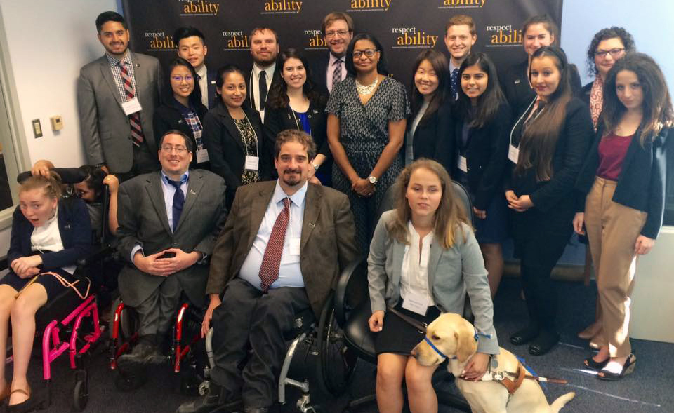 Lisa Thomas and RespectAbility Fellows standing and seated in a posed photograph, smiling for the camera