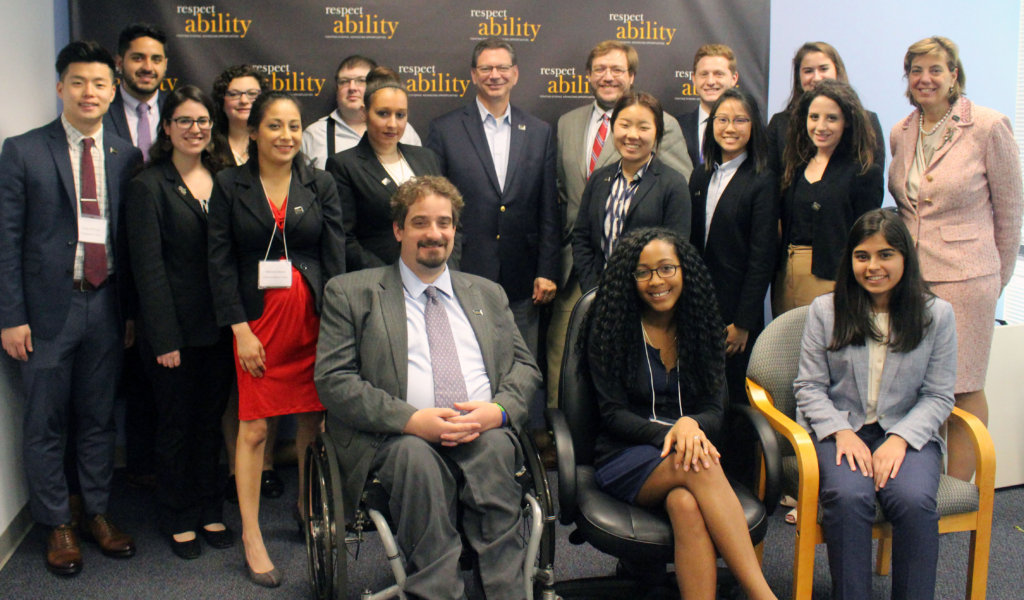 Steve Rakitt and RespectAbility Fellows standing and seated in a posed photograph, smiling for the camera