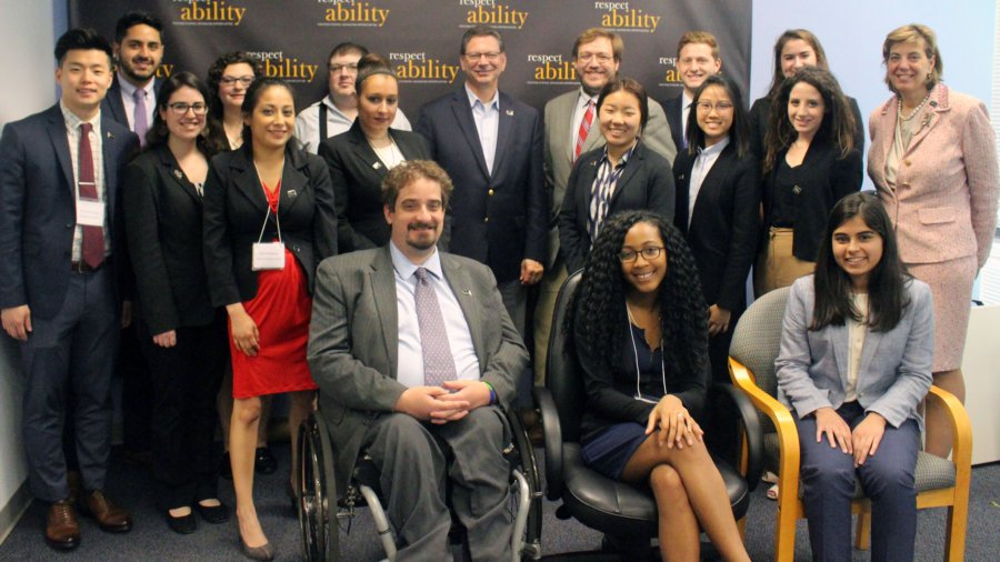 Steve Rakitt and RespectAbility Fellows standing and seated in a posed photograph, smiling for the camera