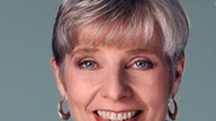 headshot of Eleanor Clift smiling and facing the camera wearing hoop earrings color photo