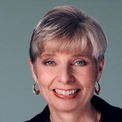 headshot of Eleanor Clift smiling and facing the camera wearing hoop earrings color photo