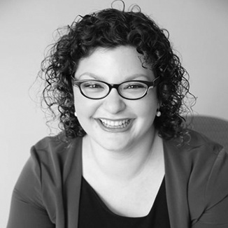 headshot of Emma Adelman smiling with curly hair grayscale photo