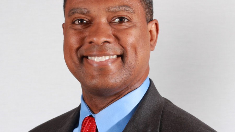 headshot of Gerard Robinson smiling and facing the camera wearing a black suit blue shirt and red tie color photo