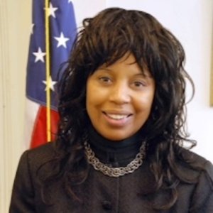 RespectAbility board member Janet LaBreck smiling in front of an American flag