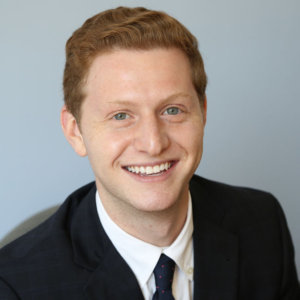 Matt Lerner wearing a suit and tie smiling