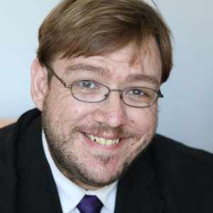 headshot of Philip Kahn Pauli wearing glasses and with beard and mustache color photo