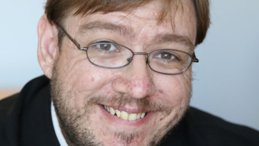 headshot of Philip Kahn Pauli wearing glasses and with beard and mustache color photo