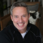 headshot of Rick Guidotti smiling and facing the camera color he has gray hair and he is wearing a black jacket color photo