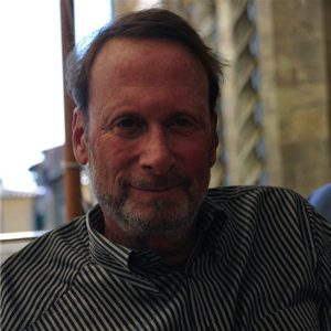 Robert Schwartz wearing a black and white striped shirt and with a light beard and mustache color photo