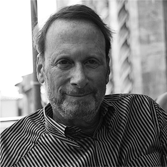 Robert Schwartz wearing a striped shirt and with a light beard and mustache grayscale photo