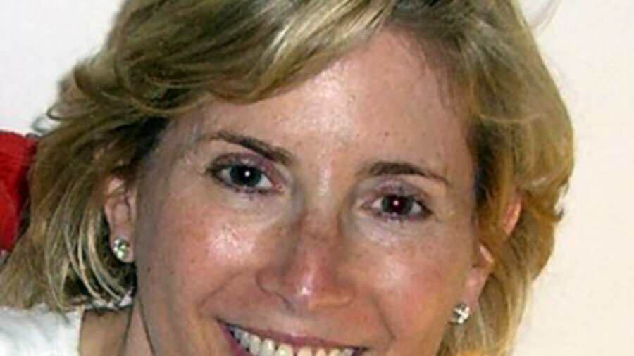 Shelley Cohen is smiling at the camera, her blonde hair is messy and she is wearing small earrings grayscale photo