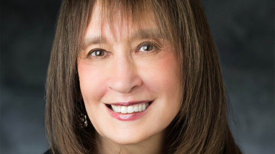 headshot of Vivian Bass smiling at the camera with long hair color photo