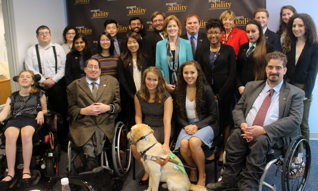 All of the fellows and staff standing in a large group against the wall with the RespectAbility logo all over it