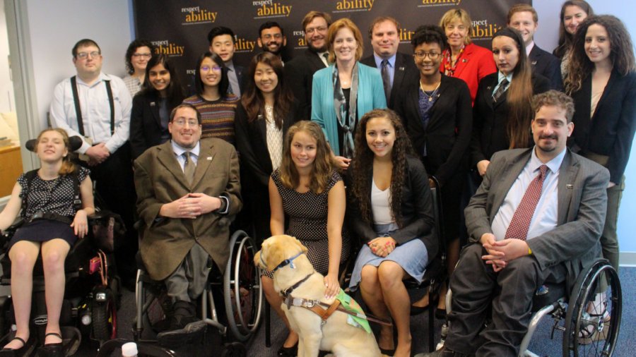 All of the fellows and staff standing in a large group against the wall with the RespectAbility logo all over it