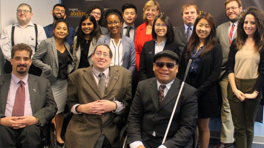 All of the fellows and staff standing in a large group against the wall with the RespectAbility logo all over it