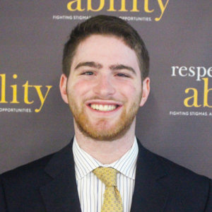 Respectability fellow Adam Fishbein smiling in front of the Respectability banner
