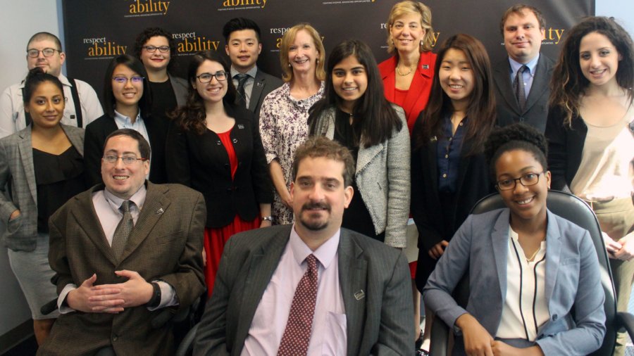 All of the fellows and staff standing in a large group against the wall with the RespectAbility logo all over it