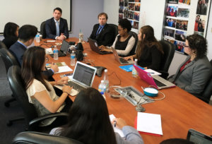 Geoffrey Maleda speaking to RespectAbility Fellows seated around a large brown table