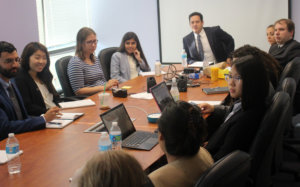 Gideon Culman speaking to RespectAbility Fellows seated around a large brown table