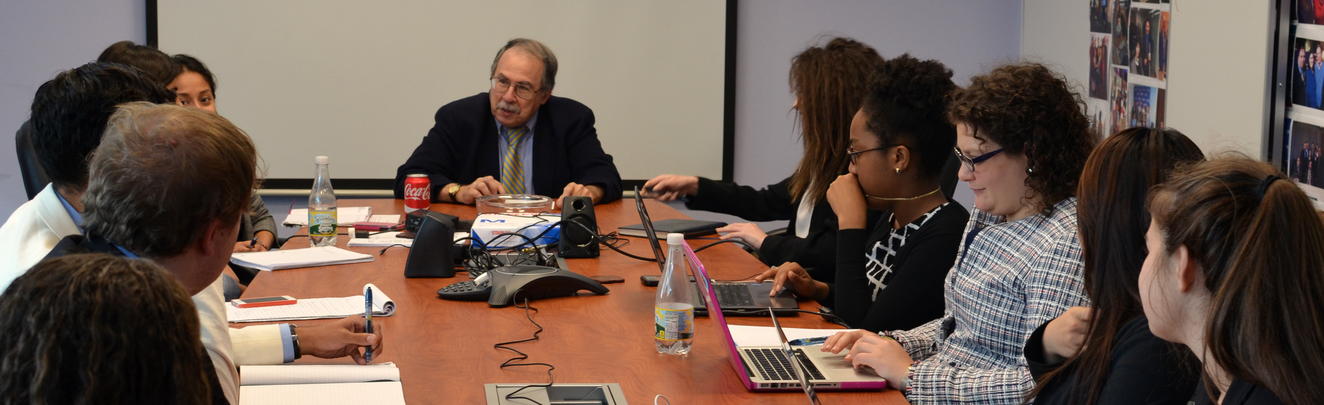 Jonathan D Salant speaking to RespectAbility Fellows seated around a large brown table