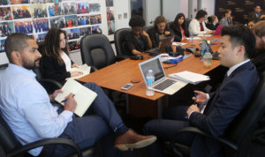 Julian A. Haynes speaking to RespectAbility Fellows seated around a large brown table