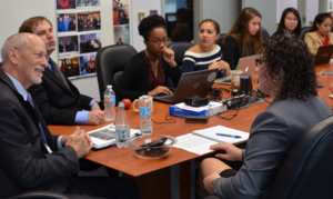 Patrick McCarthy speaking to RespectAbility Fellows seated around a large brown table