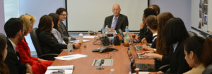 Patrick McCarthy speaking to RespectAbility Fellows seated around a large brown table