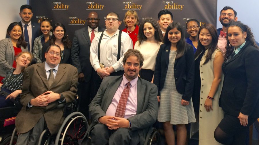 All of the fellows and staff standing in a large group against the wall with the RespectAbility logo all over it