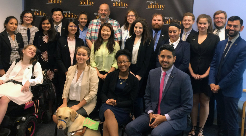 All of the fellows and staff standing in a large group against the wall with the RespectAbility logo all over it