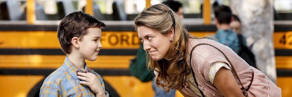 Nine-year-old Sheldon wearing a bow tie talking to his mom in front of a school bus