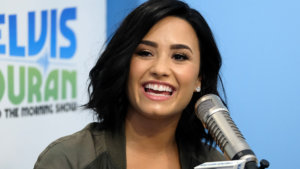Demi Lovato smiling at a microphone