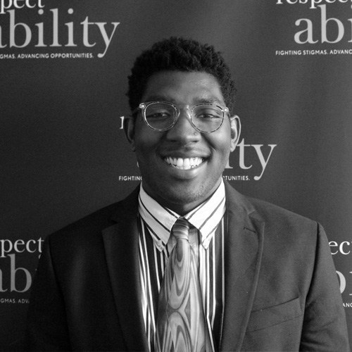 Respectability Fellow Christopher Coleman smiling in front of the Respectability banner