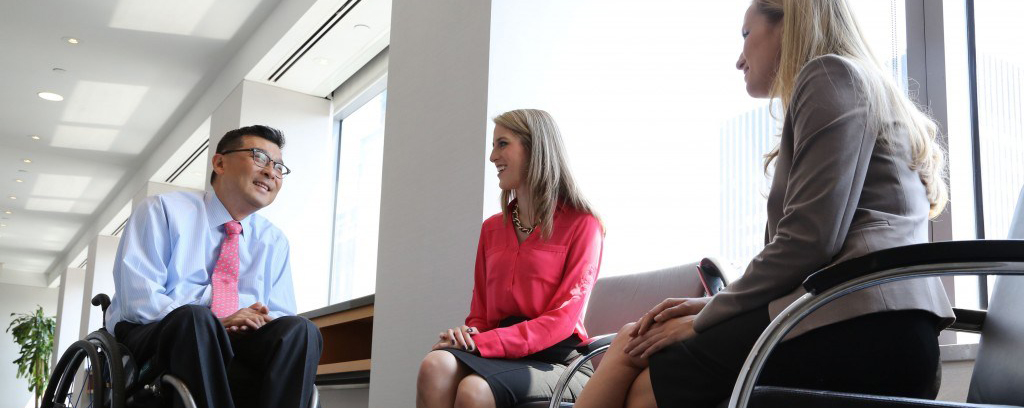 Won Shin, senior manager in transaction advisory services at EY, speaks with coworkers Alejandra Preciat and Frances Smith