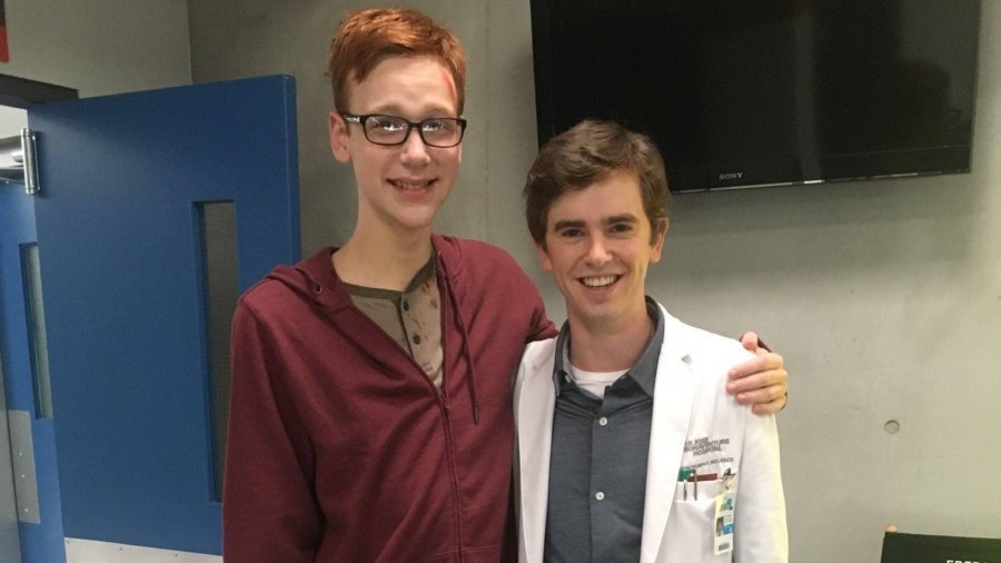 Coby Bird and Freddie Highmore standing and posing on set for the camera