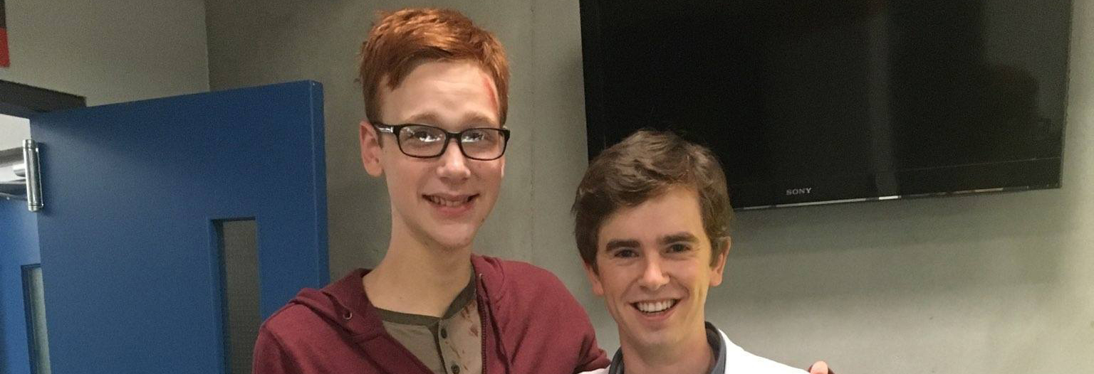 Coby Bird and Freddie Highmore standing and posing on set for the camera
