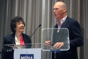 Fern Field and Michael Keaton speaking behind the podium