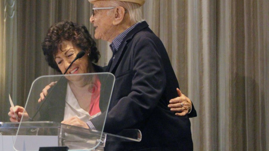 Fern Field and Norman Lear hugging behind the poidum