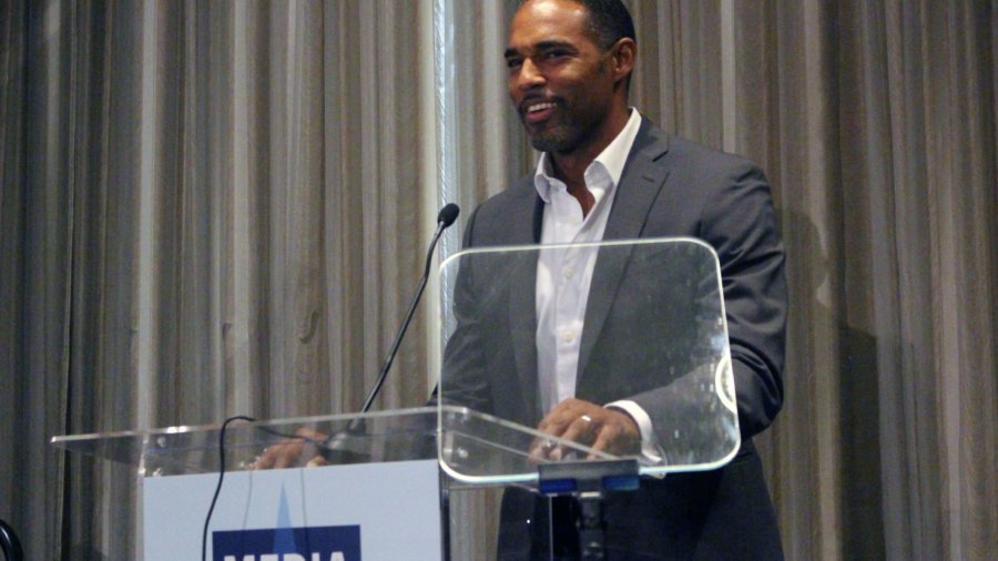 Jason George standing at a podium with the sign Media Access Awards