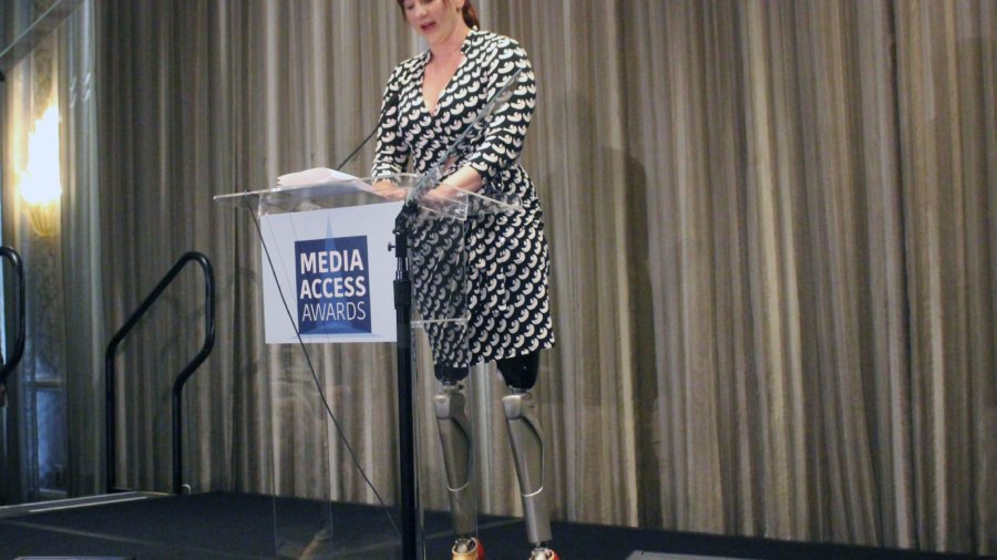 Katy Sullivan presenting the award - prosthetic legs are visible